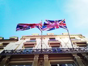 low-angle-view-flag-against-building-against-blue-sky