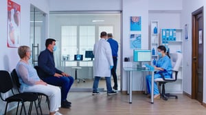 senior-man-filling-document-hospital-waiting-area-before-medical-examination-nurse-wearing-face-mask-against-infection-with-coronavirus-private-hospital-busy-waiting-area