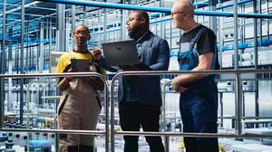 smart-factory-manager-teaching-workers-manage-robotic-arms-using-laptop
